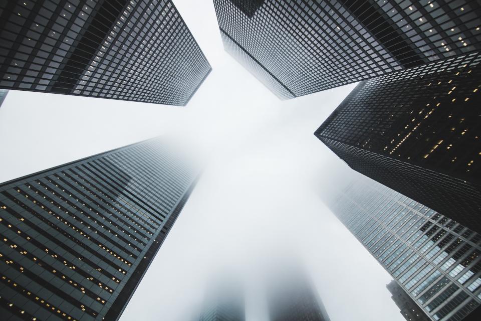 Abstract navy and gold toned photo of skyscrapers seen from below, representing Bending Spoons acquiring Airtable