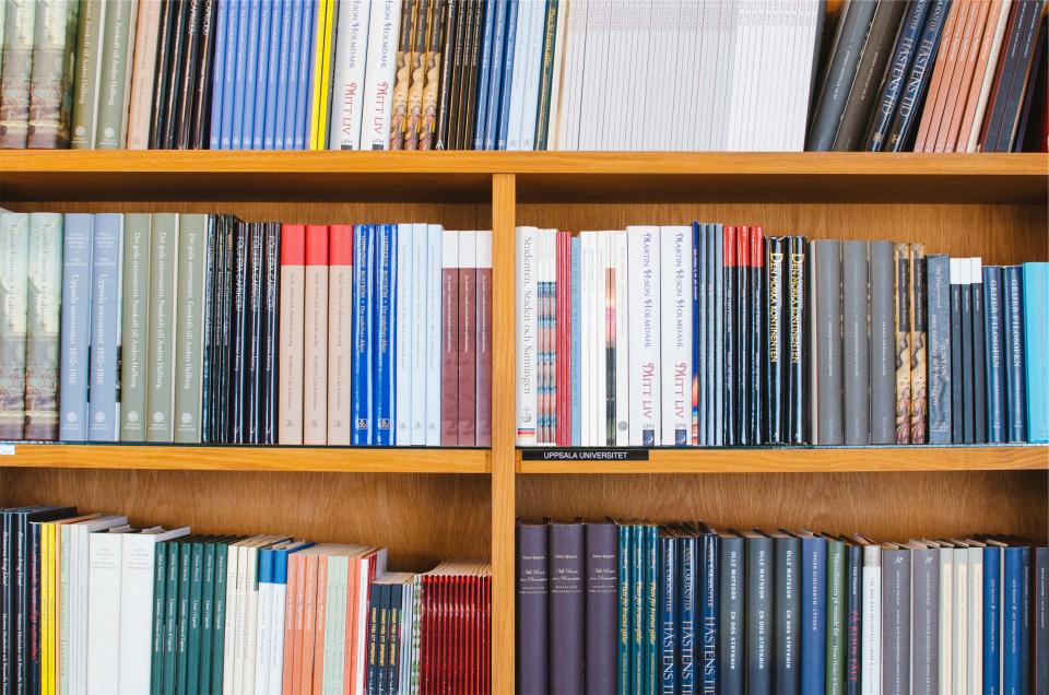 Abstract navy and gold toned photo of a bookshelf, representing Anthropic’s shifting model lineup