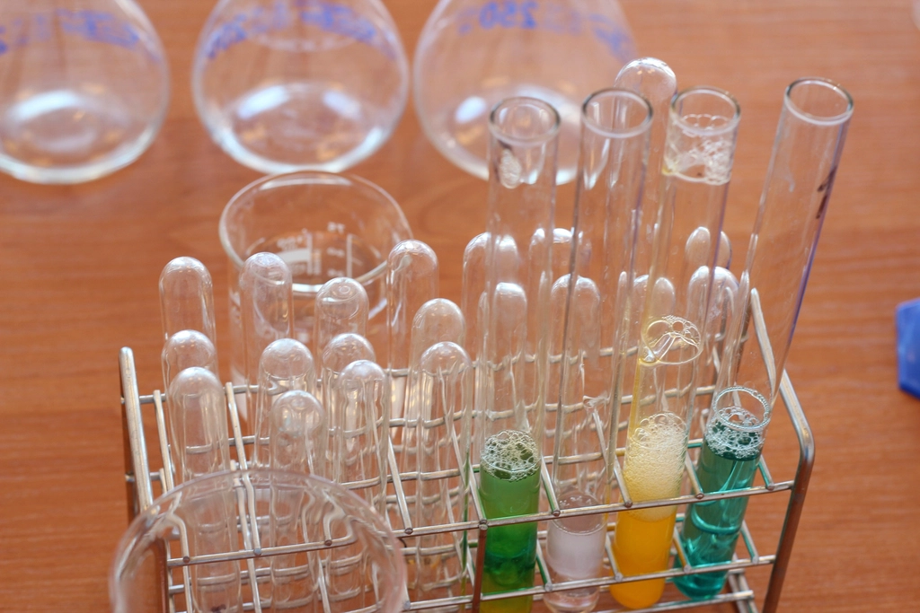 Abstract navy and gold toned photo of laboratory glassware and test tubes, representing Claude Science for research