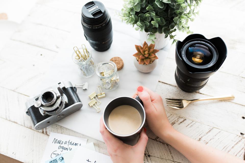 Abstract navy and gold toned photo of cameras and lenses on a desk, representing the Google Pics image tool