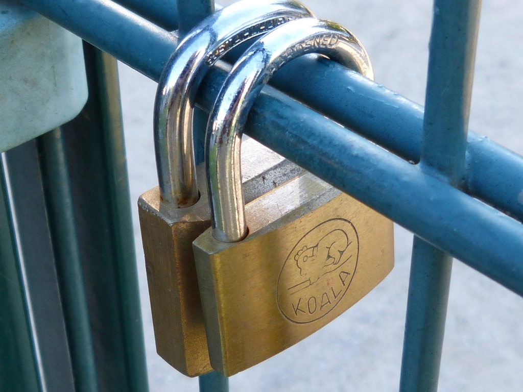 Navy and gold toned photo of a padlock on a metal gate, representing Gemini 4 Argon for cybersecurity defenders
