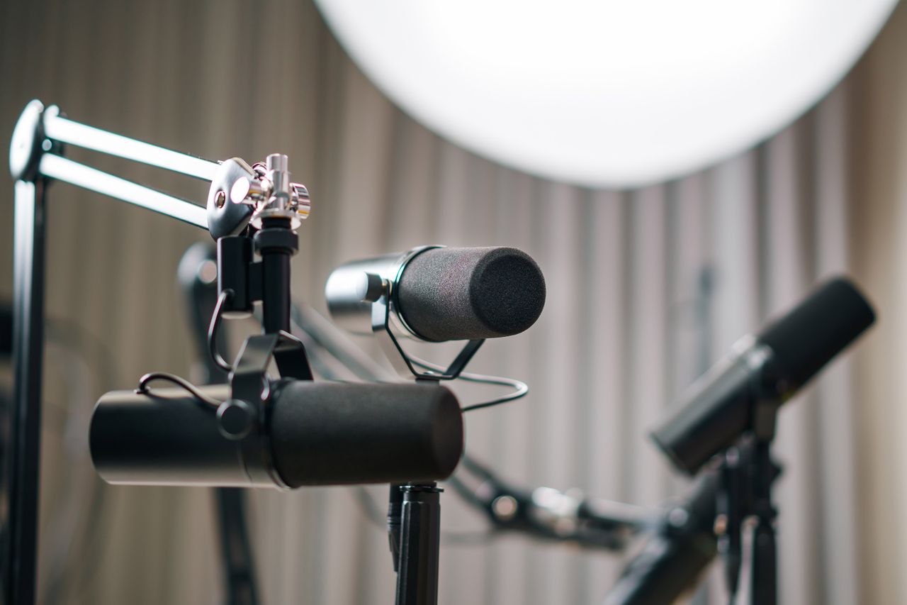 Navy and gold toned photo of studio microphones, representing ElevenLabs and AI voice